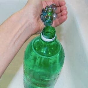 Putting marbles and water inside a pop bottle to displace water in a toilet.