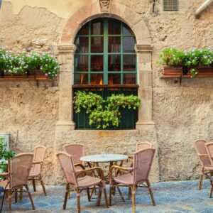 An outdoor cafe with chairs and a table in Sicily.