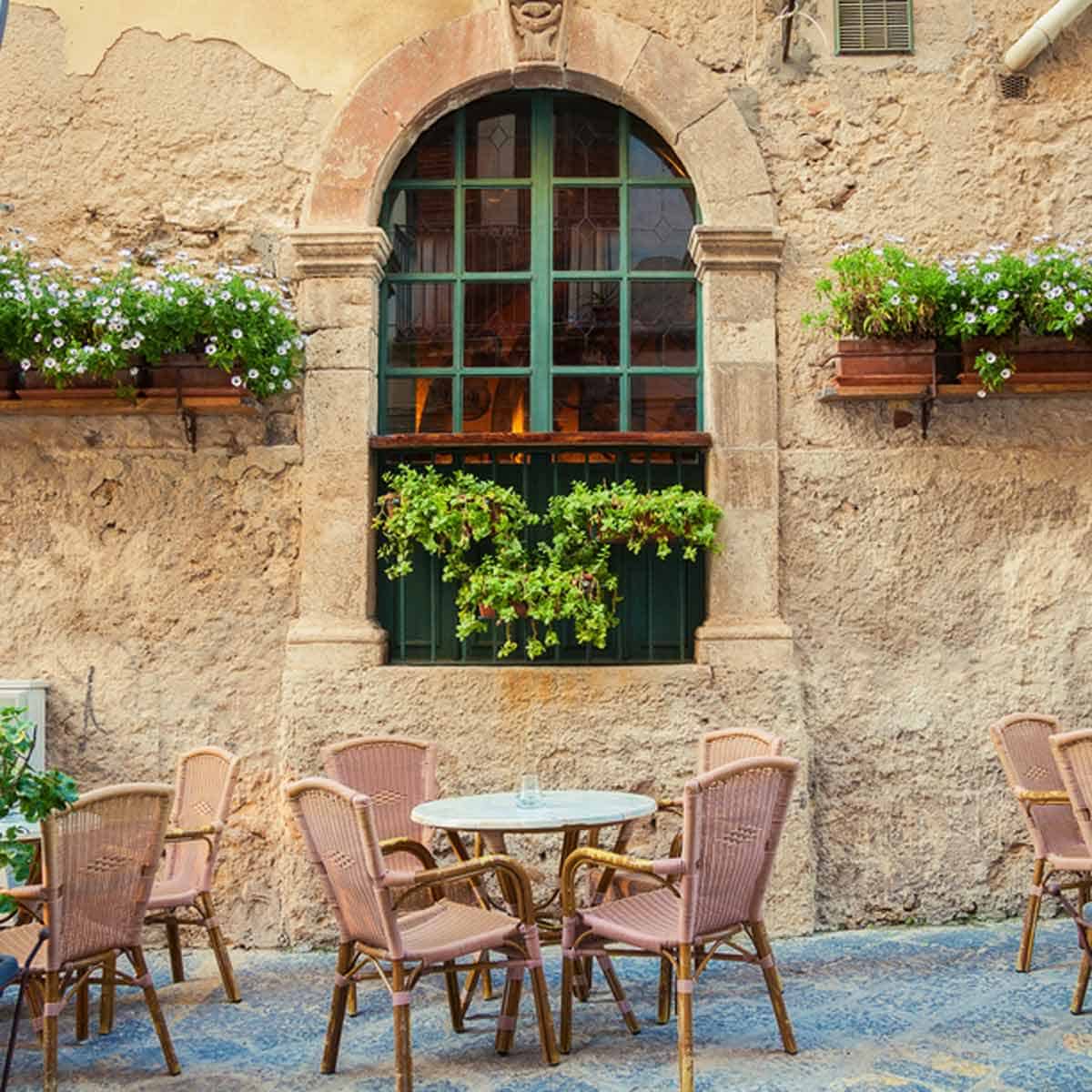 An outdoor cafe with chairs and a table in Sicily.