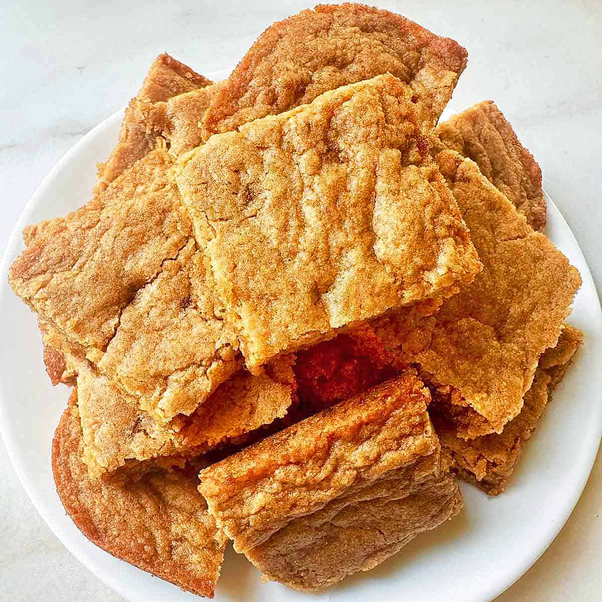 A batch of homemade butterscotch cookie bars stacked on a plate.