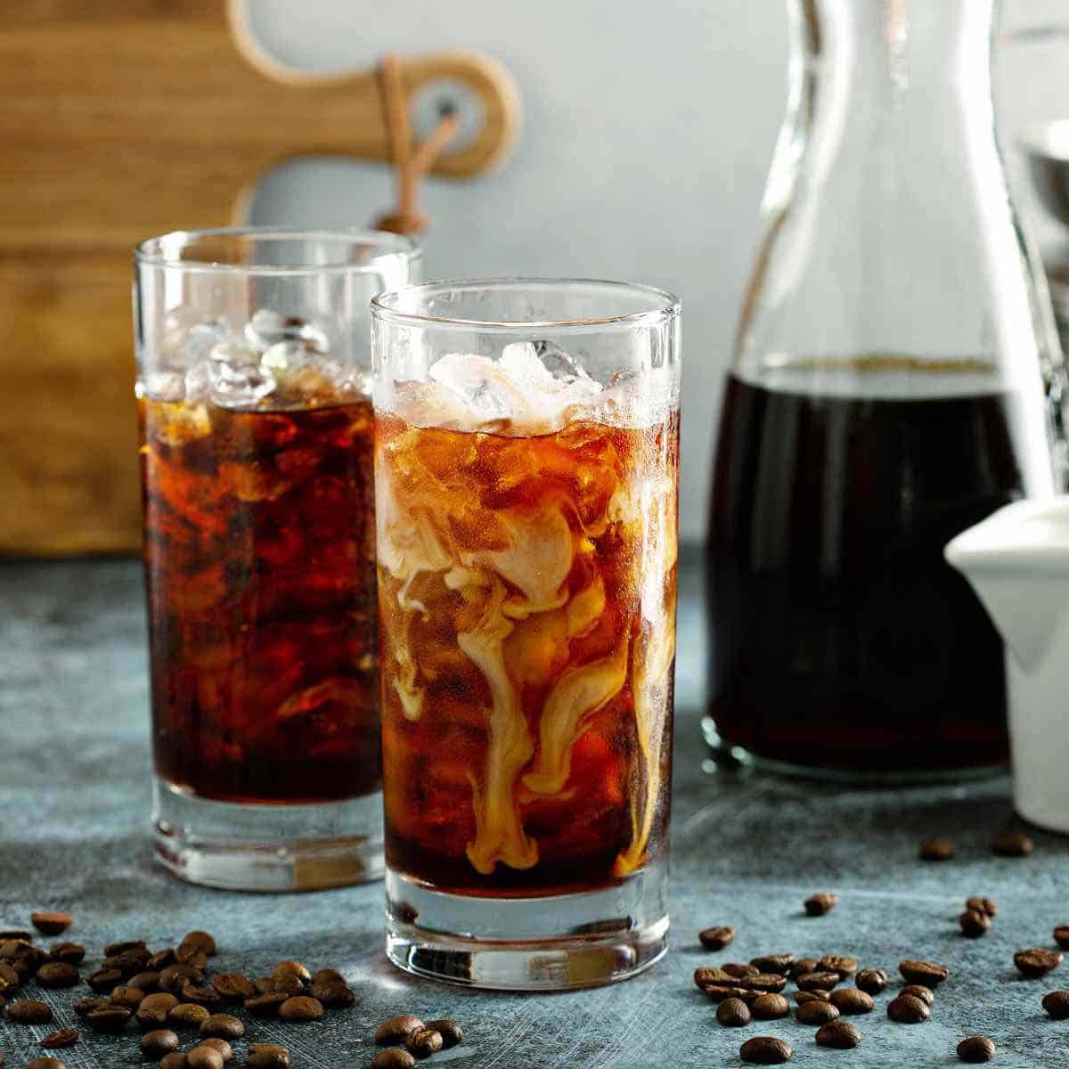 A bottle of liquid coffee concentrate and two glasses of iced coffee.