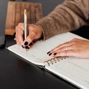 A woman writing in a gratitude journal