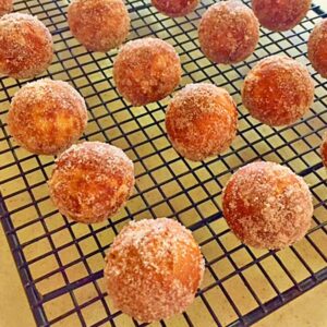 Just baked pumpkin donut holes cooling on a wire rack.