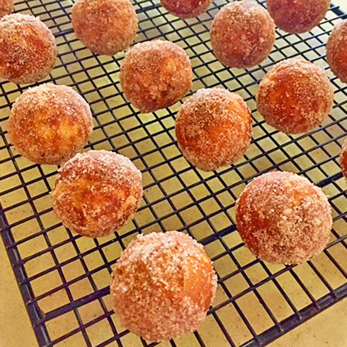 Just baked pumpkin donut holes cooling on a wire rack.