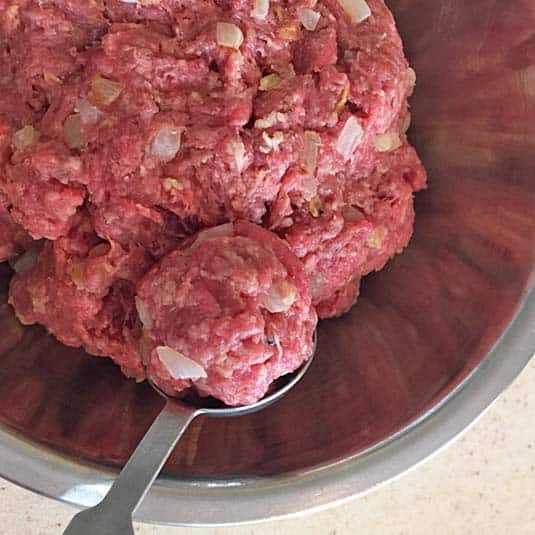 Shaping the meatballs with a spoon.