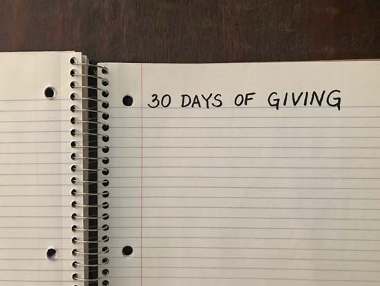 A notebook with "30 Days of Giving" written at the top of a page.