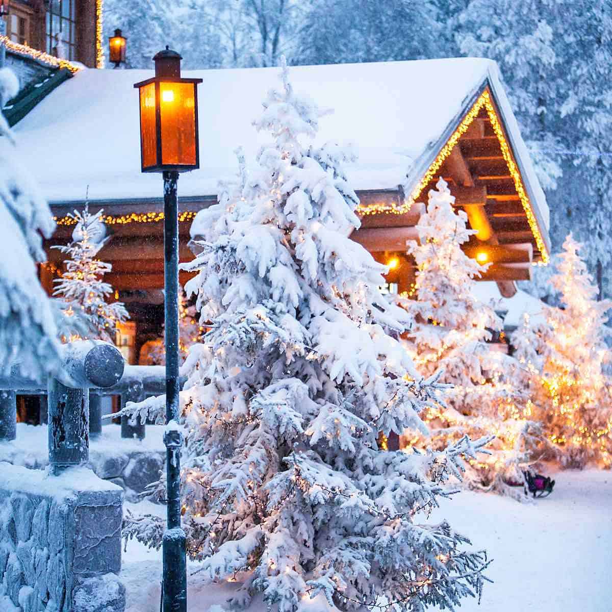A snowy cabin decorated with little white Christmas lights.