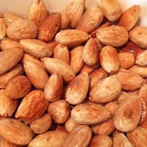 Close up of a pile of golden brown roasted almonds.
