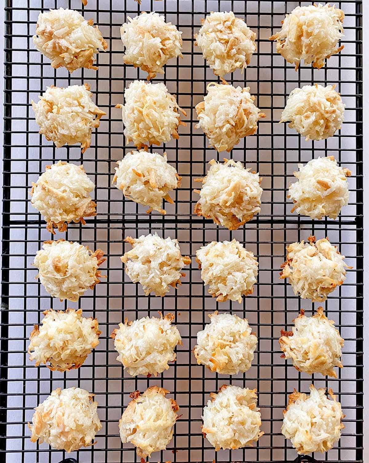 Baked coconut almond macaroons on a wire cooling rack.