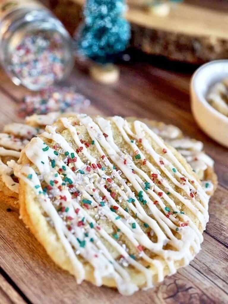 Two pan banging sugar cookies decorated with red and green holiday sprinkles.