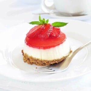 Close up of a mini strawberry cheesecake topped with fresh strawberries.