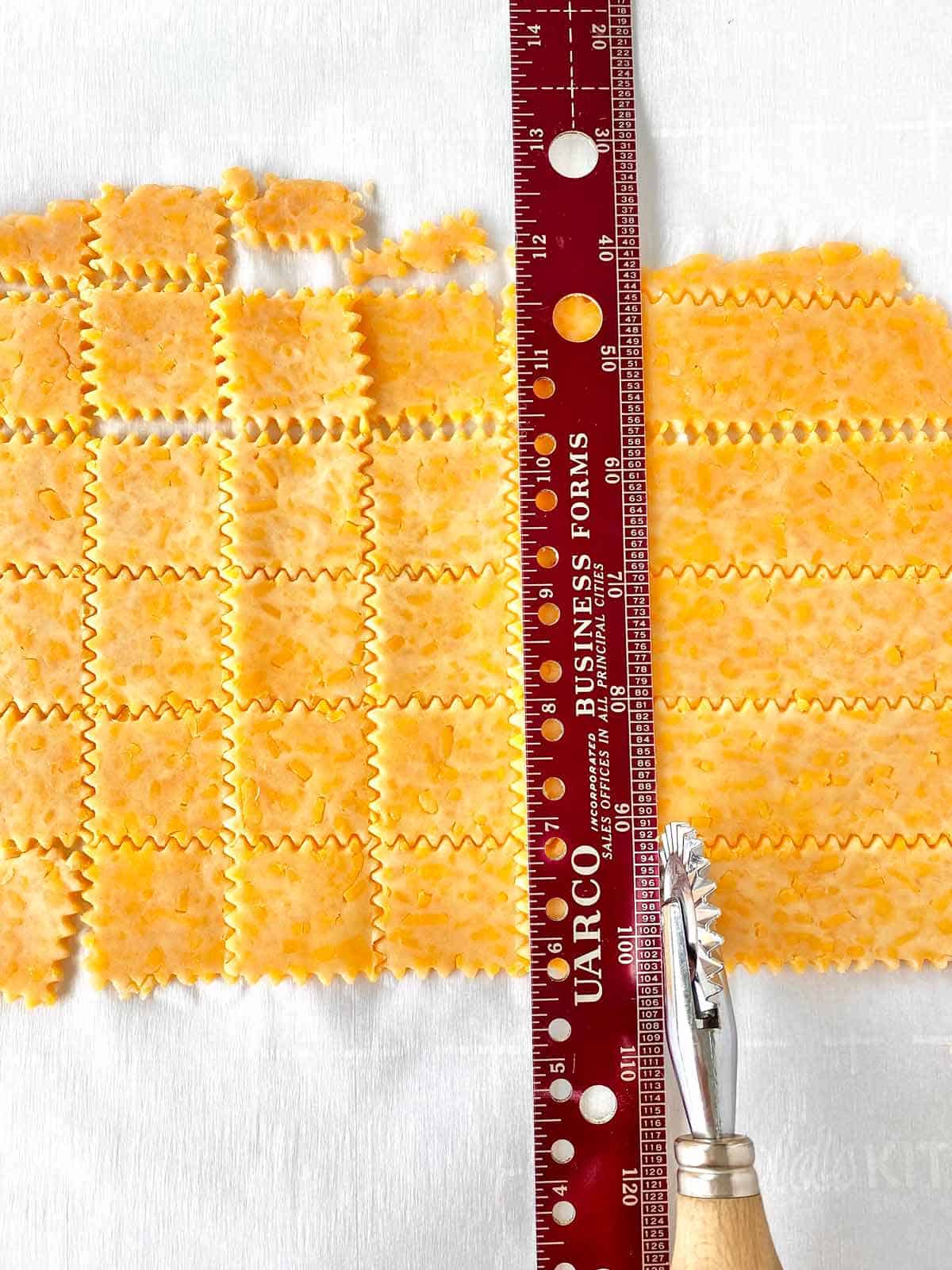 Measuring and cutting homemade crackers in squares.