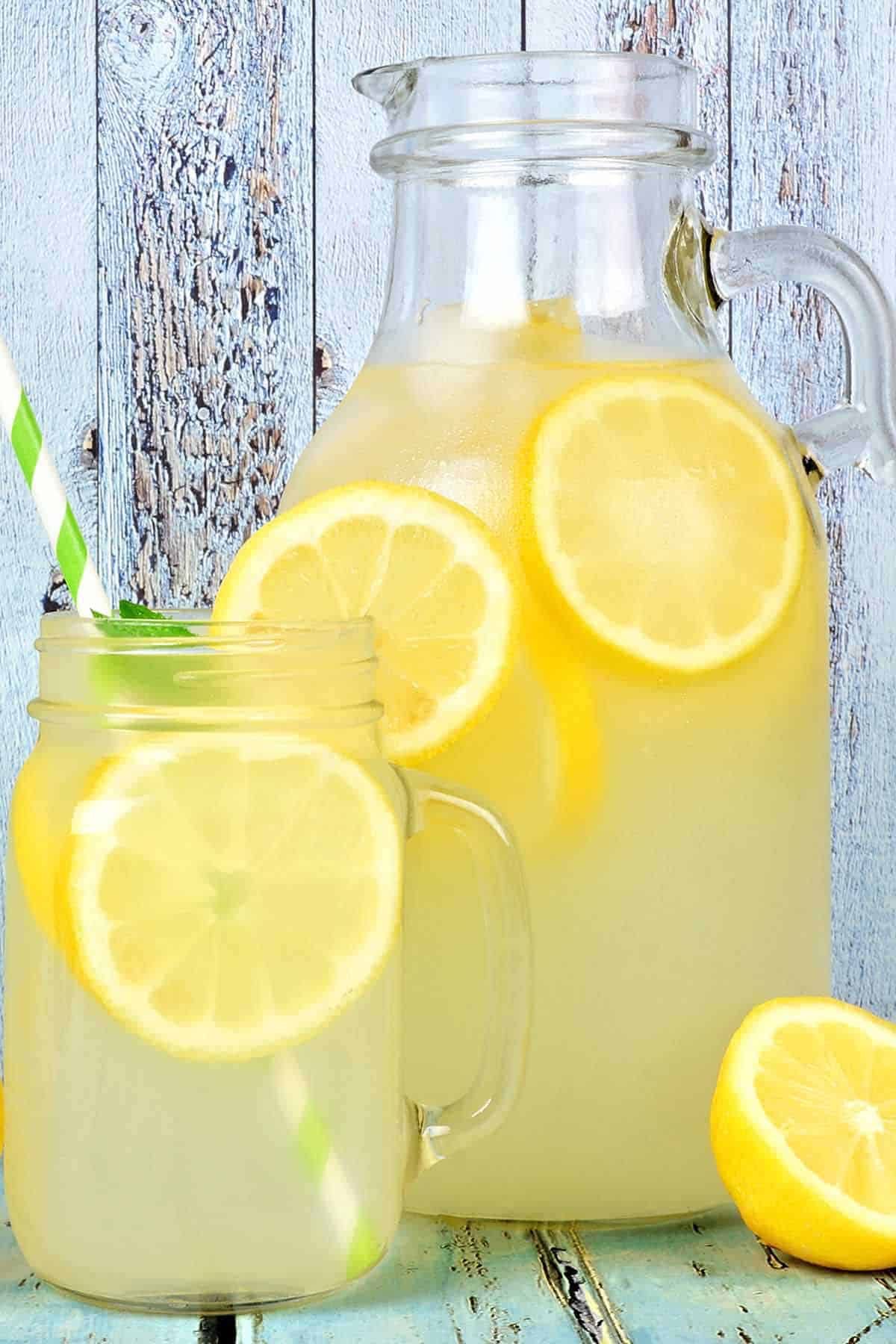 Pitcher with two glasses of homemade lemonade and fresh lemons.