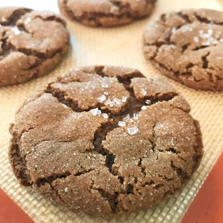 a perfectly baked molasses crinkle cookie topped with white crystal sugar.