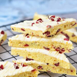 Six cranberry cookie bars stacked on a cooling rack.