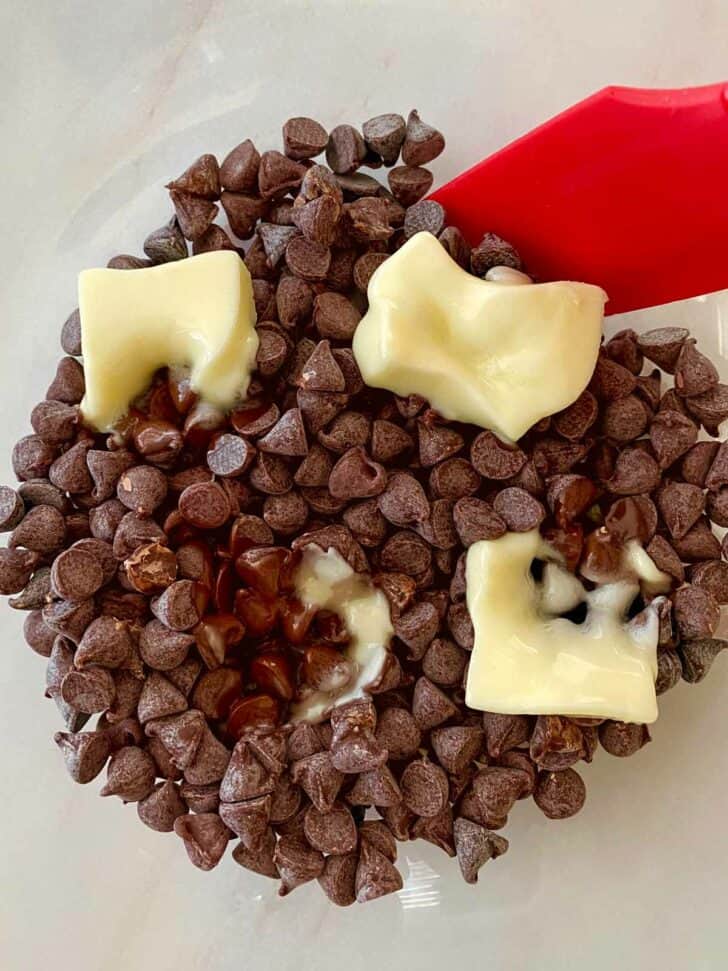 Combining butter and melting chocolate chips in a bowl.