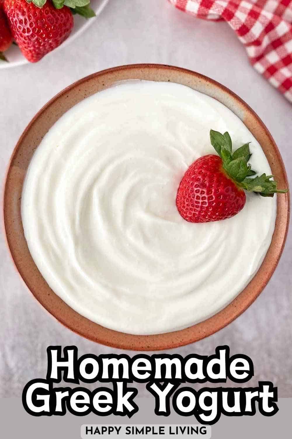 A bowl of Greek yogurt with a fresh strawberry on top.