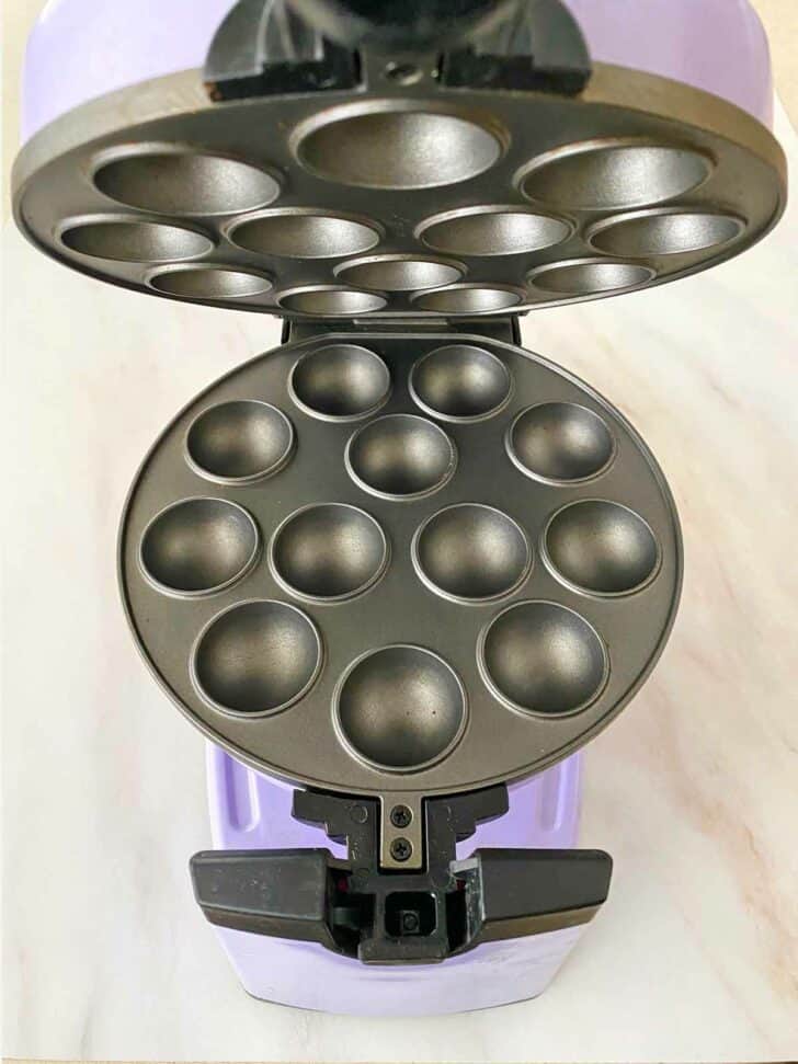 An open cake pops maker showing the 12 cups for making donut holes.