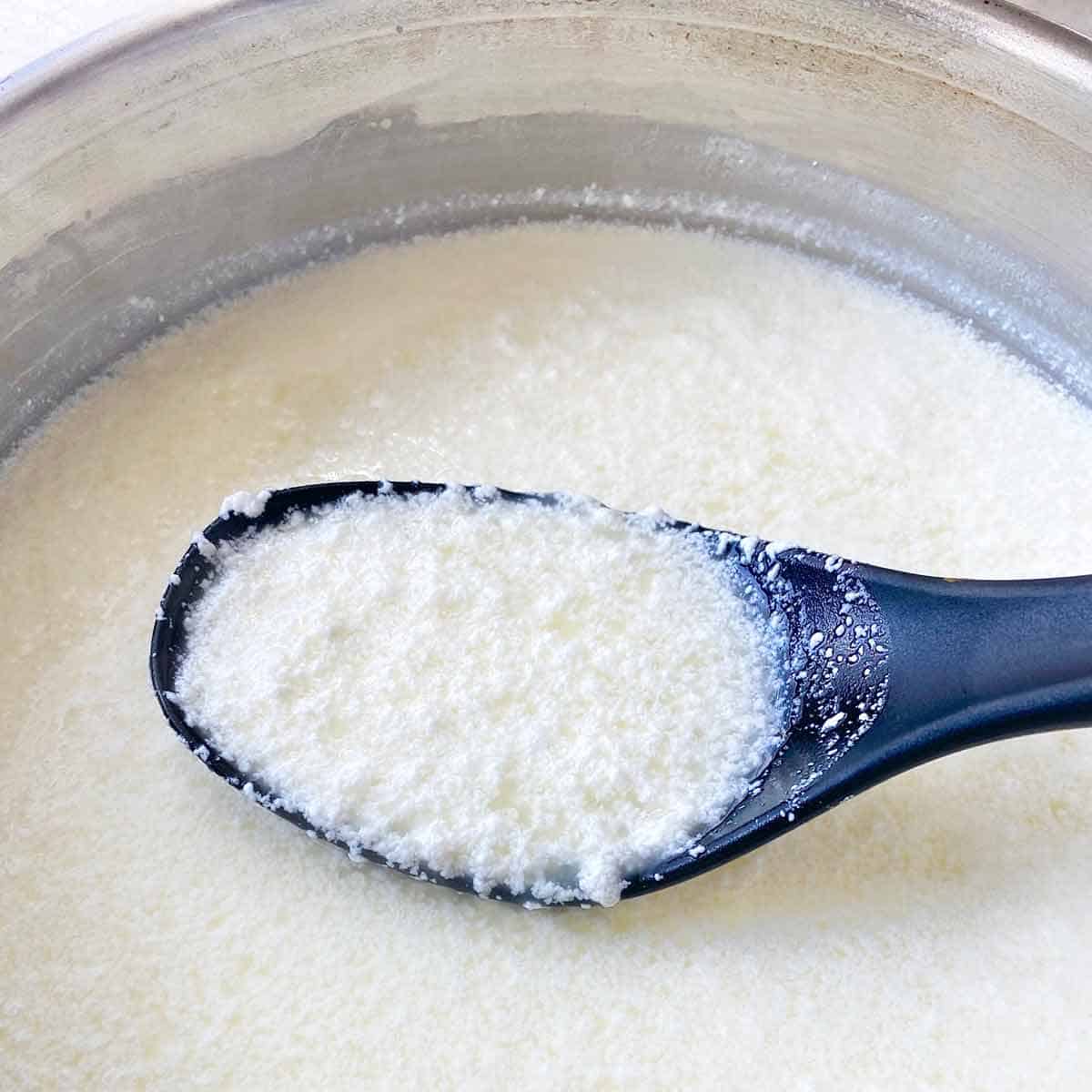 Milk visibly starting to curdle after adding lemon juice.