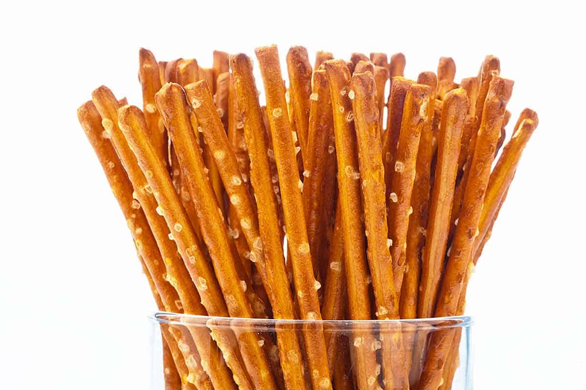 Three dozen pretzel sticks in a clear glass.