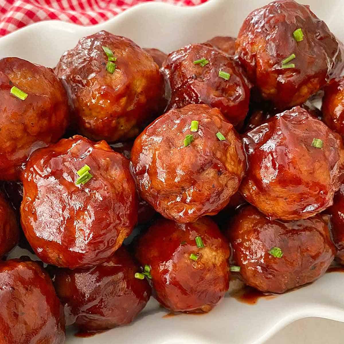 Cranberry sauce meatballs sprinkled with chives, ready to serve.