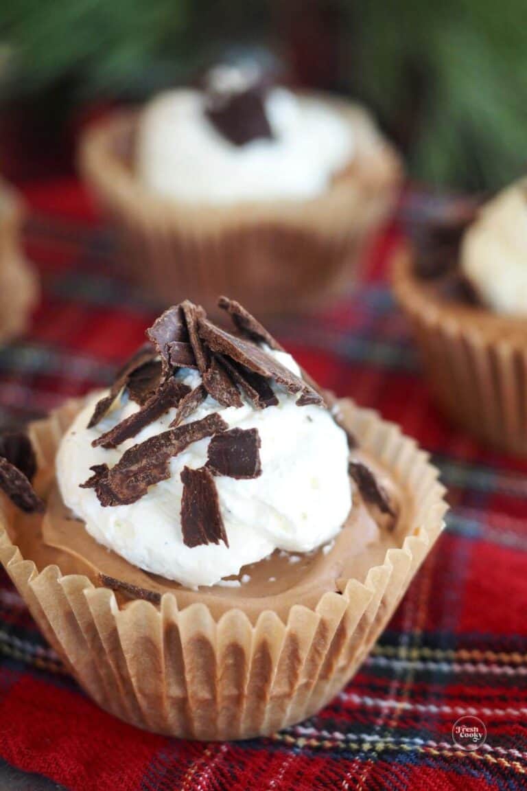 Three mini French silk pies on a red plaid tablecloth.