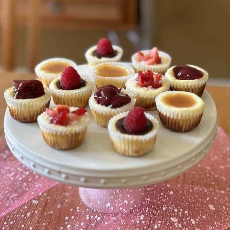A dozen mini cheesecakes on a white cake stand.