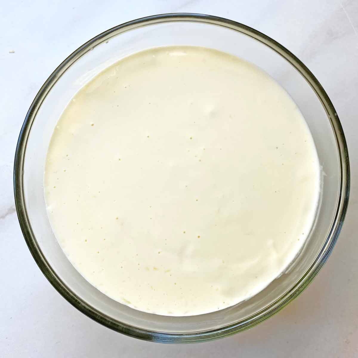 Parmesan cheese cream mixture in a glass bowl.