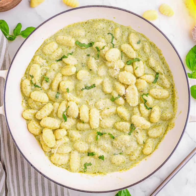 Gnocci with creamy pesto in a white bowl.