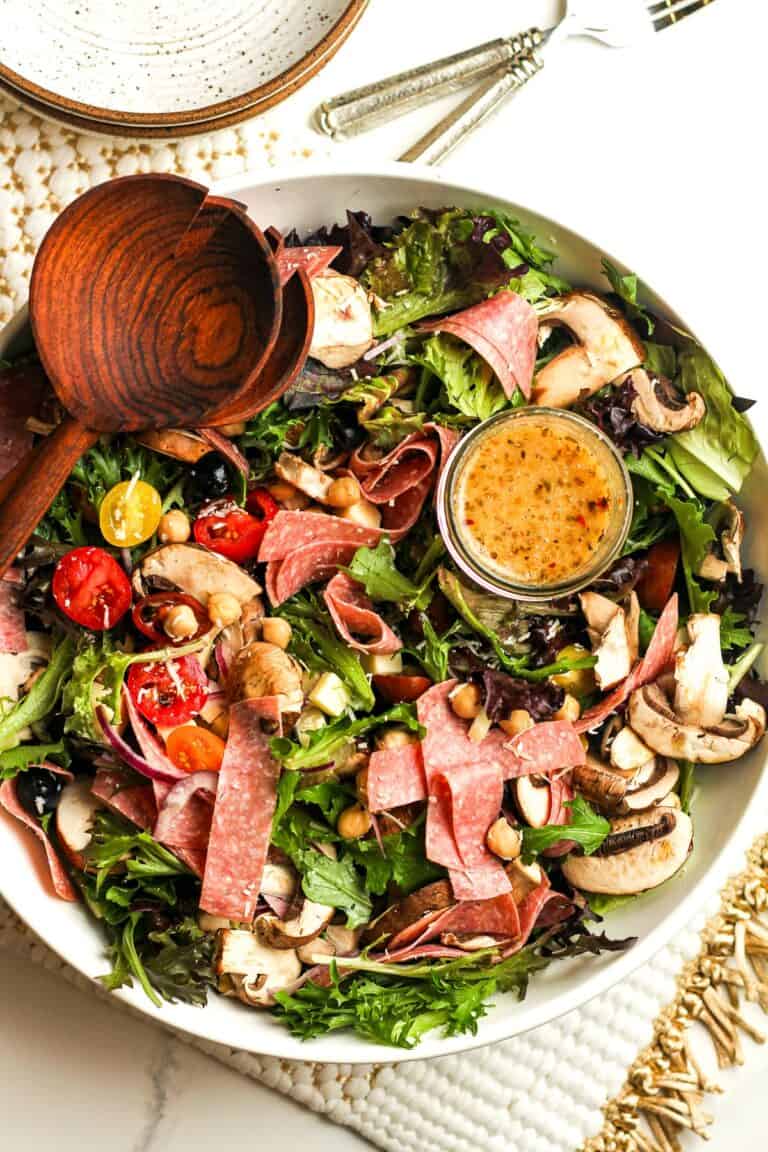 A white serving platter filled with antipasto salad.