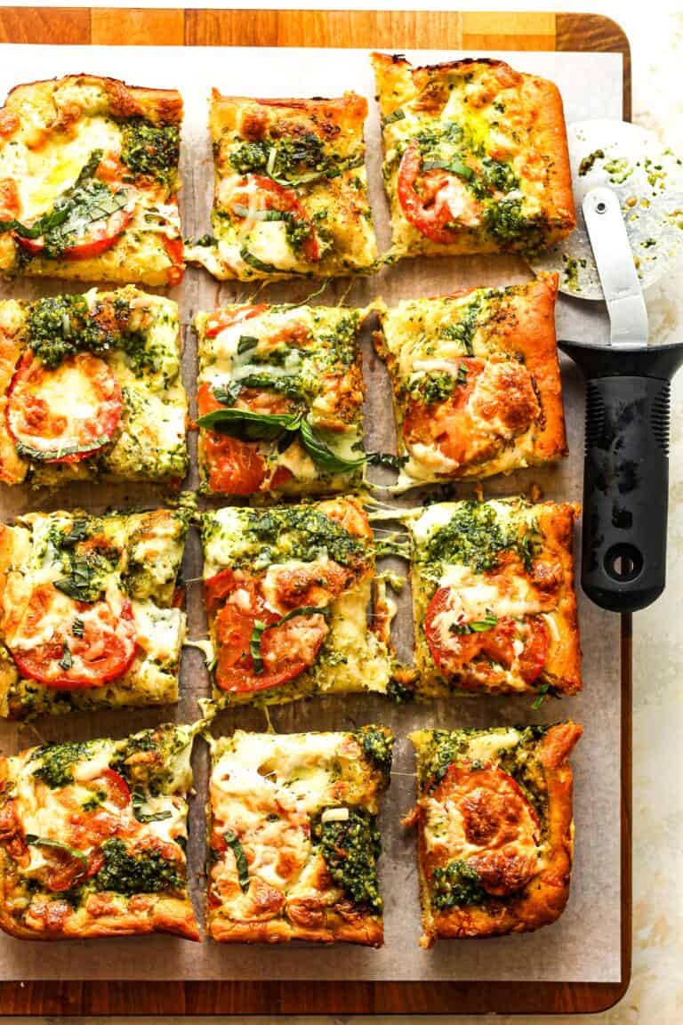 Focaccia bread with caprese topping on a cutting board.