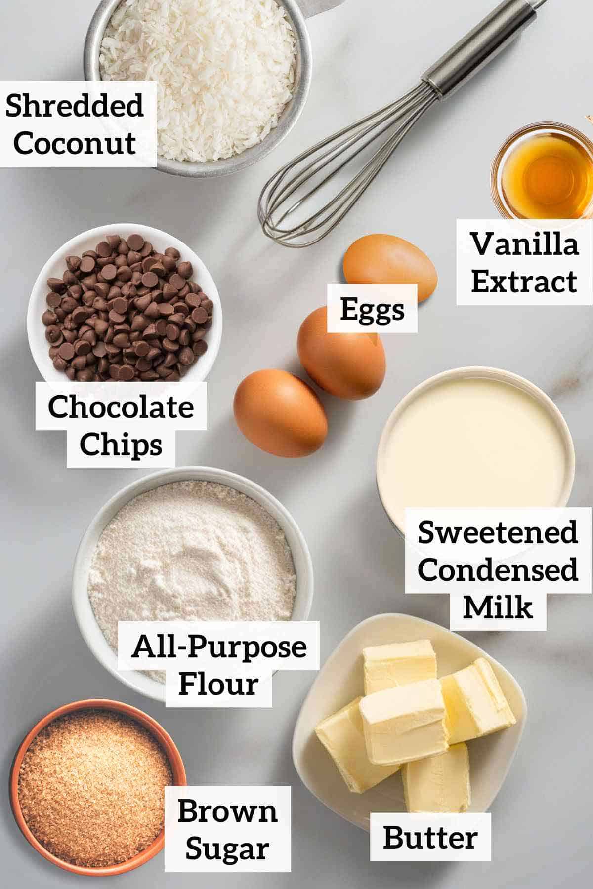 Coconut, chocolate chips, eggs, flour, butter, vanilla, brown sugar, and a whisk.