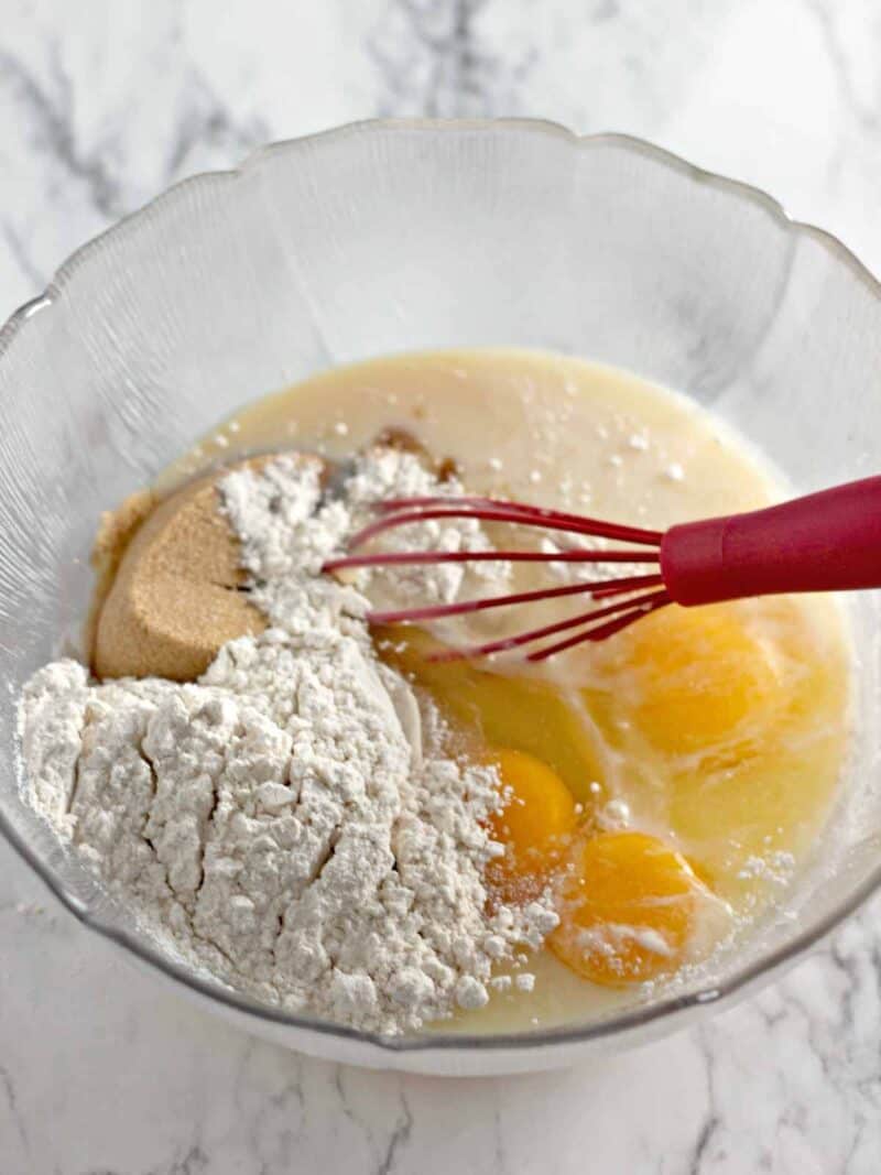 Eggs, sweetened condensed milk, vanilla, flour and brown sugar in a mixing bowl.