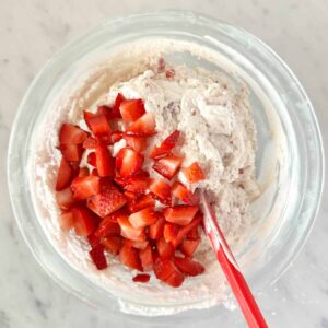 Adding the fresh chopped strawberries to the dip.