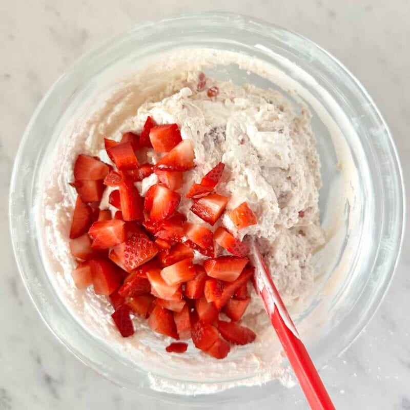 Adding the fresh chopped strawberries to the dip.