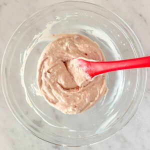 Combining strawberry jam and vanilla with the cheesecake dip mixture.