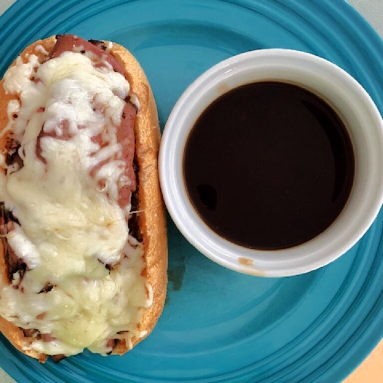 A french dip sandwich on a blue plate.