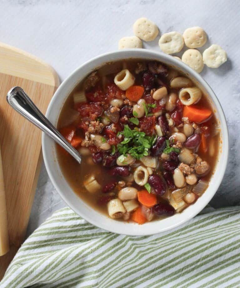 Pasta Fagioli Soup in a white bowl with a spoon.