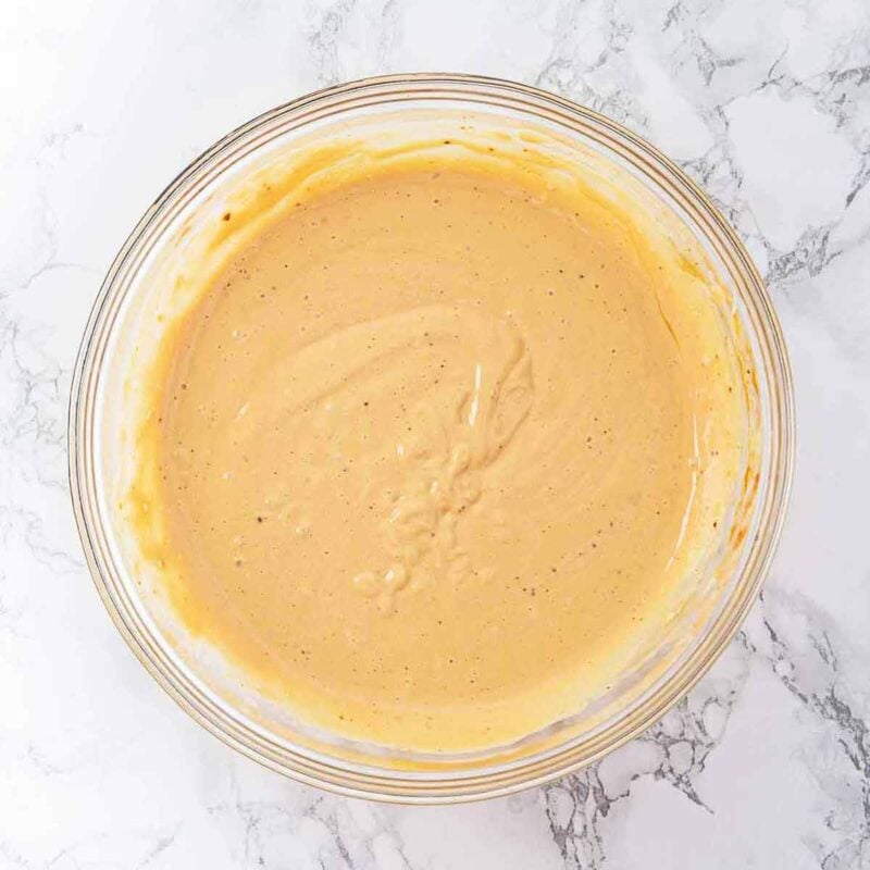 Ginger cheesecake mixture in a mixing bowl after being combined.