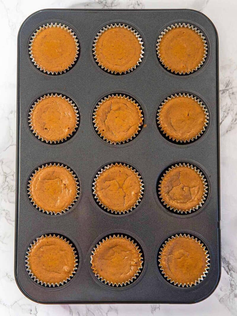 Overhead shot of baked gingerbread mini cheesecakes in the muffin tin.