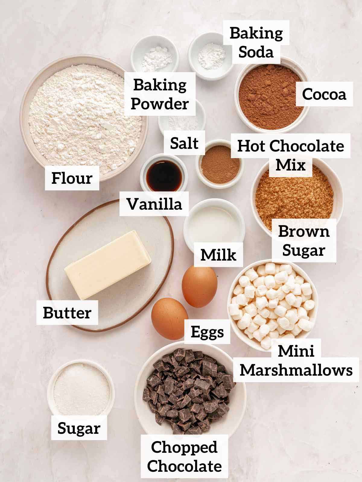 Flour, sugar, butter, cocoa, vanilla, marshmallows, chocolate, and ingredients to make hot chocolate cookies.