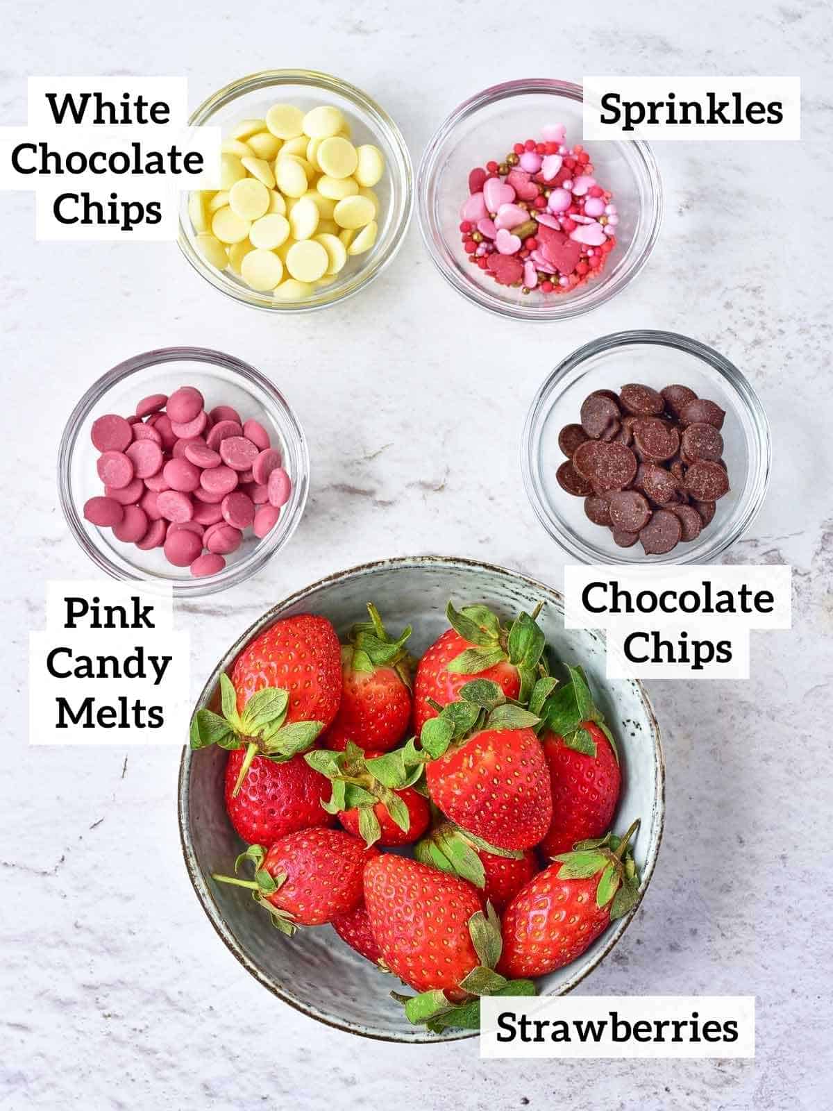 white chocolate chips, sprinkles, pink candy melts, chocolate chips, and fresh strawberries.