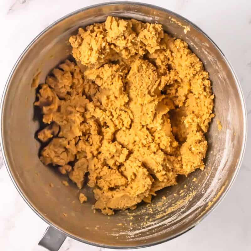 Cookie dough for s'mores bars in a stainless mixing bowl.