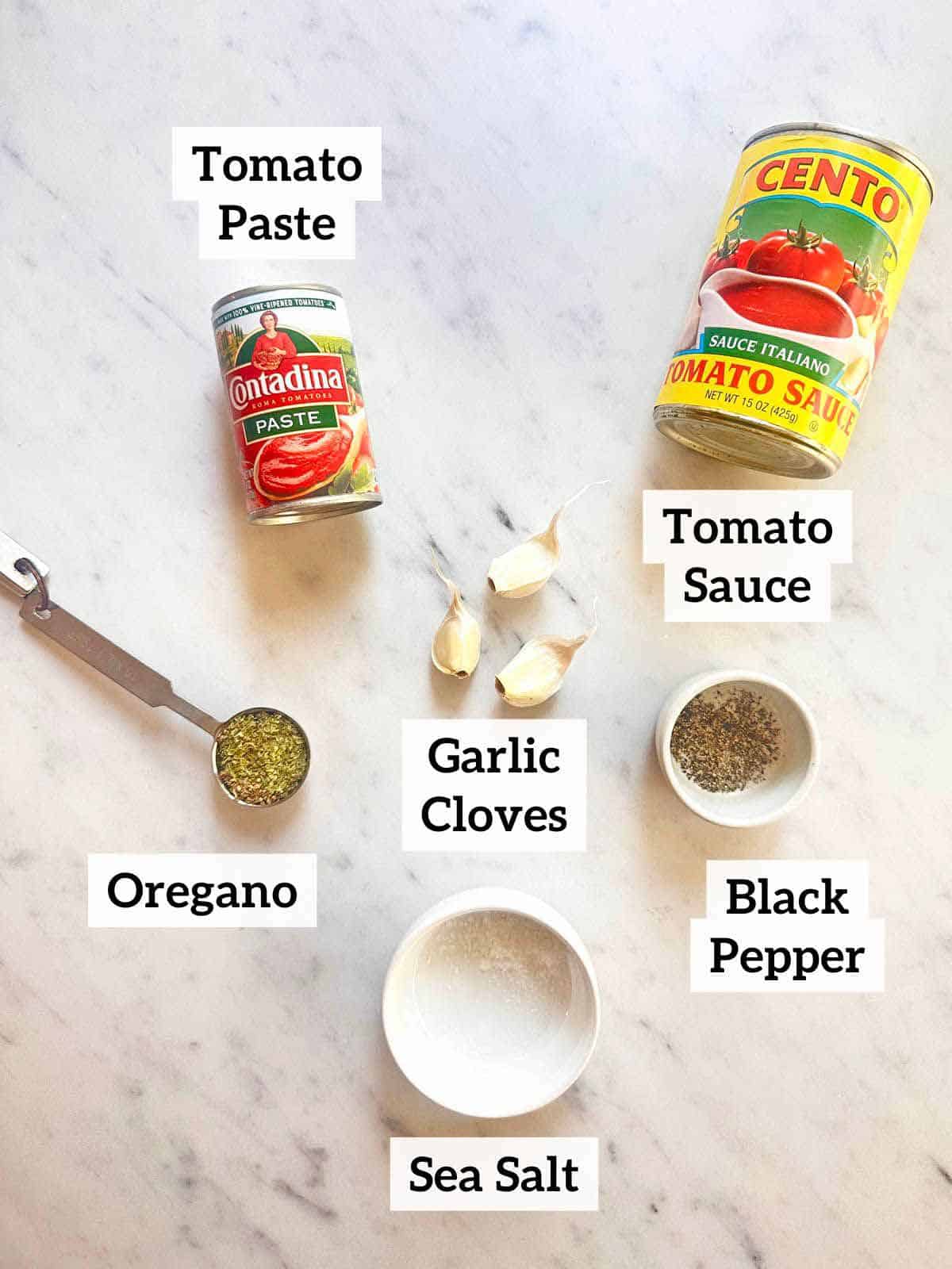 Tomato paste, tomato sauce, black pepper, garlic cloves, oregano, and sea salt.