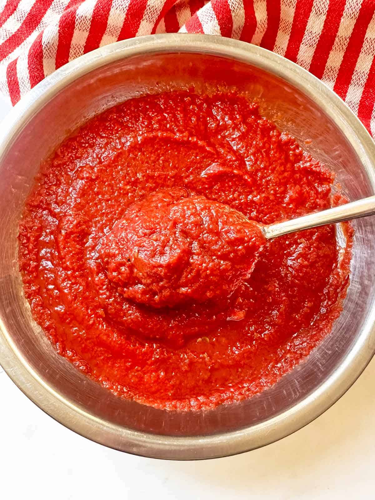 Stirring the finished pizza sauce.