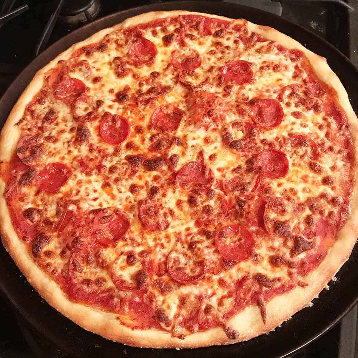 Homemade NY pizza topped with sausage and pepperoni.