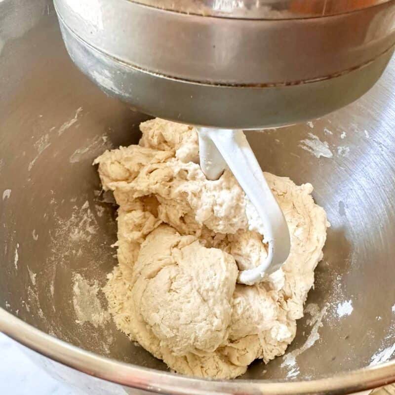 Mixing the pizza dough together in the stand mixer bowl.