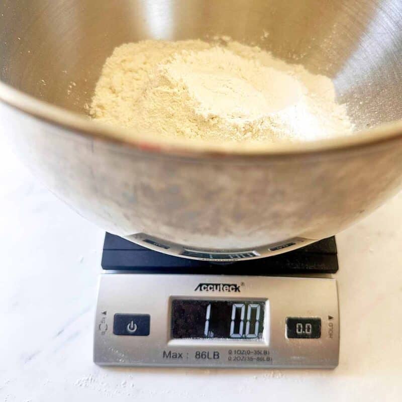 Weighing 16 ounces of bread flour on a scale.