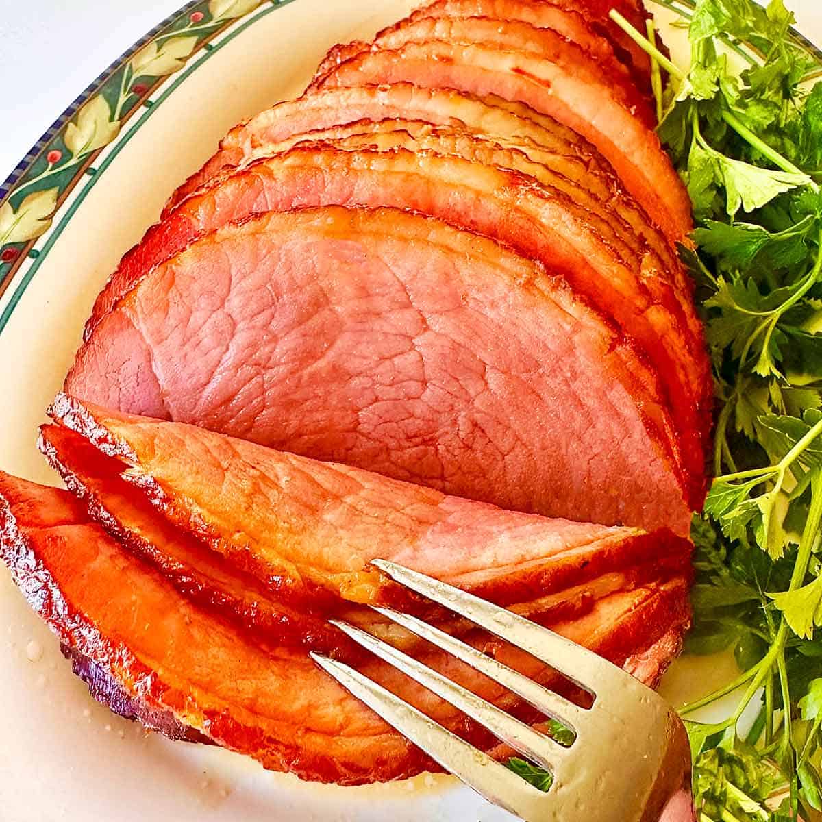 Homemade honey glazed ham with a fork, ready to serve.
